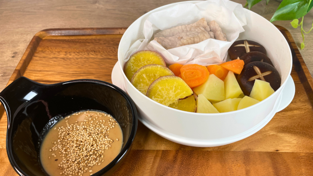 １段電子レンジ蒸し器でジャガイモニンジンなどの根菜類、豚肉やサツマイモを入れて蒸す