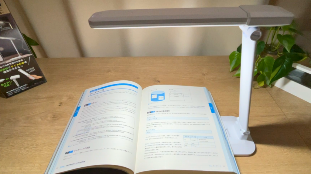 ダイソーのデスクライトを本を照らして読書する写真