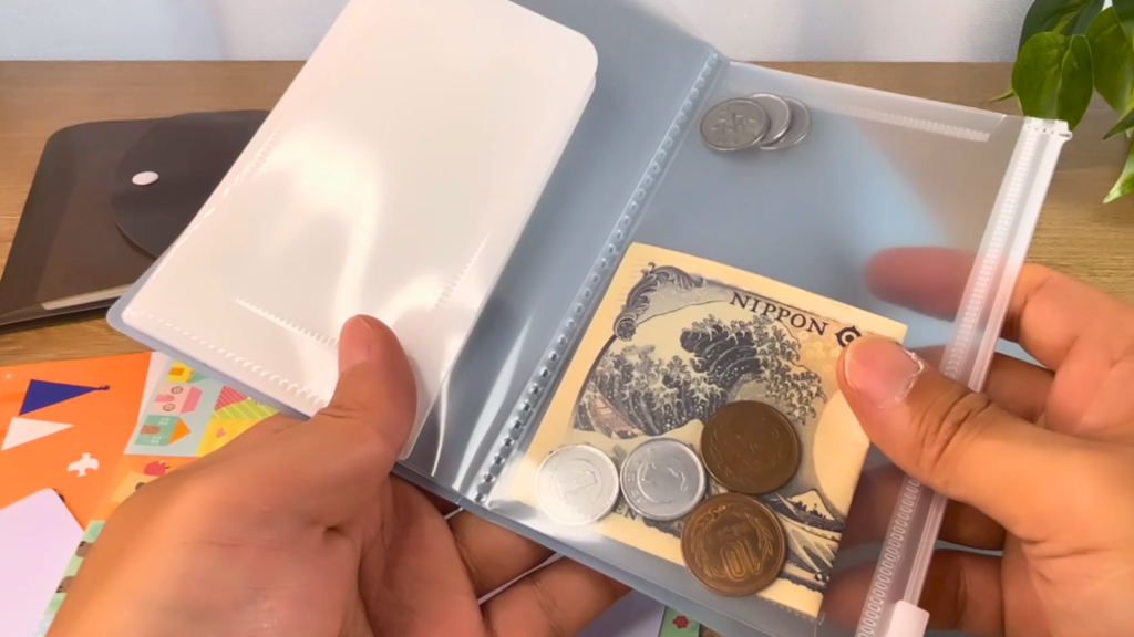 通帳ケースについているジッパーポケットにお金を入れている写真