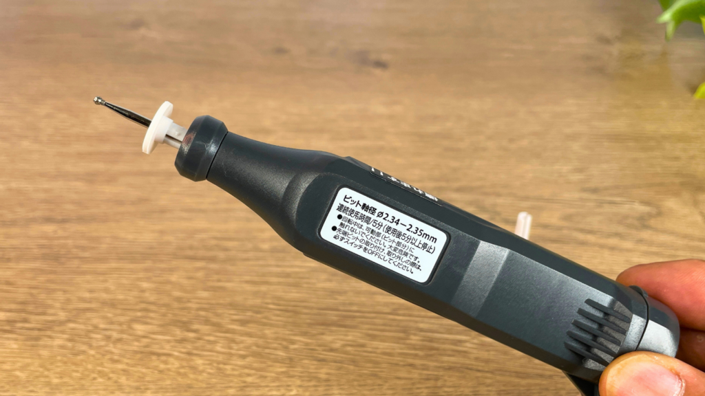 ダイソーのミニルーターを指で持っている写真