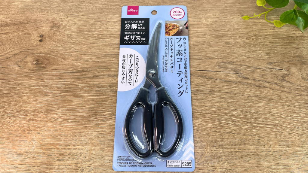 ダイソーのカーブキッチンバサミ（フッ素コーティング）を机の上においた写真（JANコード：4550480319285）