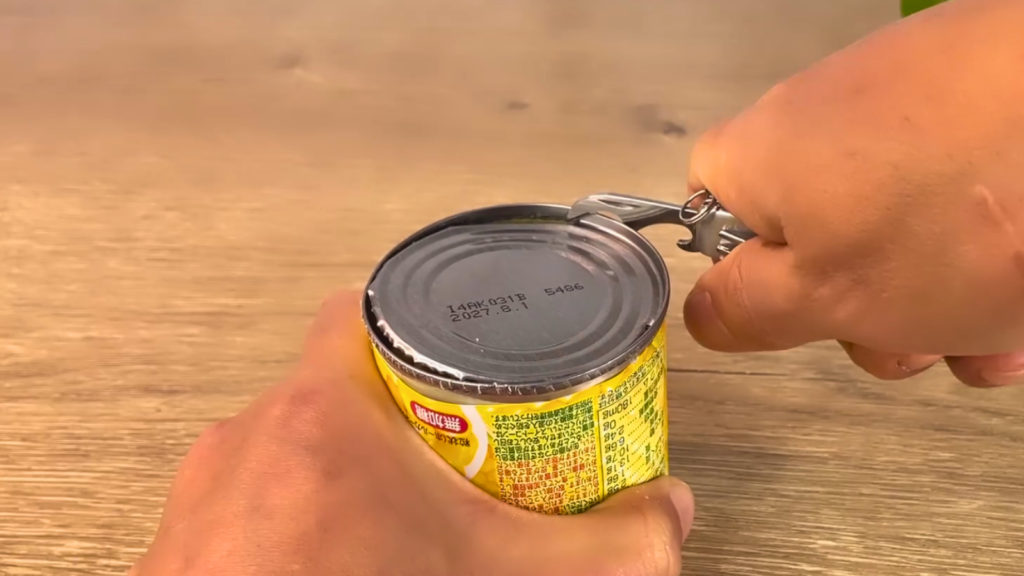 缶きりで感を切る